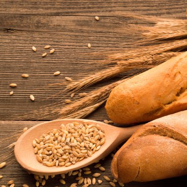 Tahıl, ekmek ve buns ahşap masa üzerine kaşıkla