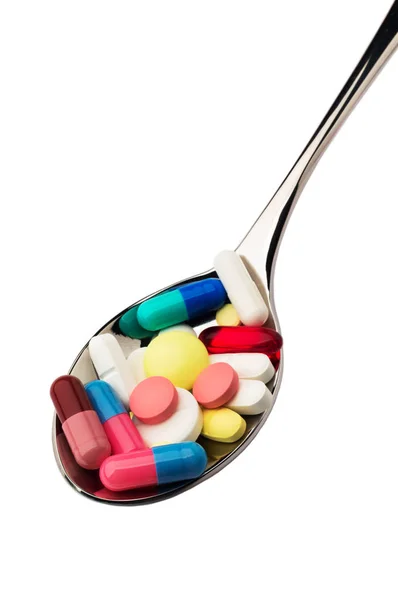 Disease. A lot of pills into spoon — Stock Photo, Image