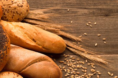 Ekmek, baget, somun ve ahşap masa üzerine buns. Yatay