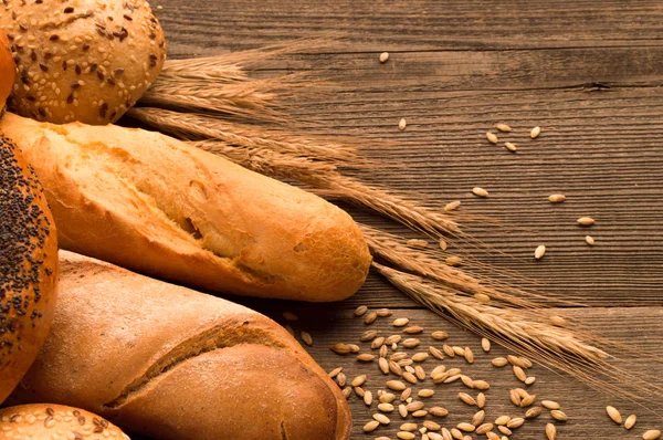 Ekmek, baget, somun ve ahşap masa üzerine buns. Yatay