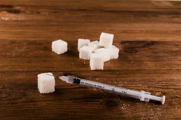 Диабет ужасная болезнь. Много кубиков сахара со шприцем — стоковое фото