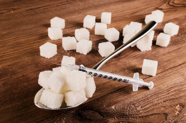 Диабет. Много кубиков сахара в ложке и инжекторе — стоковое фото