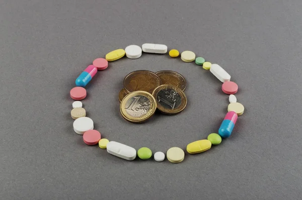 Círculo creado a partir de píldoras de colores con dinero. Concepto médico —  Fotos de Stock