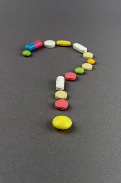 疑問符は着色された丸薬から作成されました。医療コンセプト — ストック写真