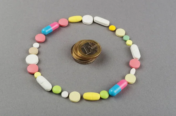 Círculo creado a partir de píldoras de colores con dinero. Concepto médico —  Fotos de Stock