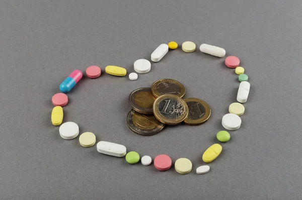 Corazón creado a partir de píldoras de colores con dinero. Concepto médico —  Fotos de Stock