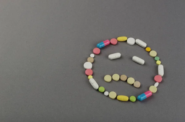 Unhappy smile created from colored pills. Medical concept — Stock Photo, Image