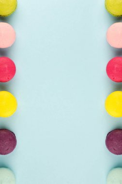 Mavi arka plan, üstten görünüm üzerinde renkli Fransızca macaroons