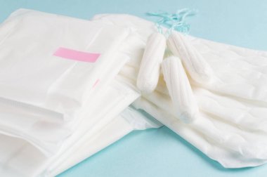 Adet tampon ve yastıkları mavi bir arka plan üzerinde. Adet döngüsü. Hijyen ve koruma