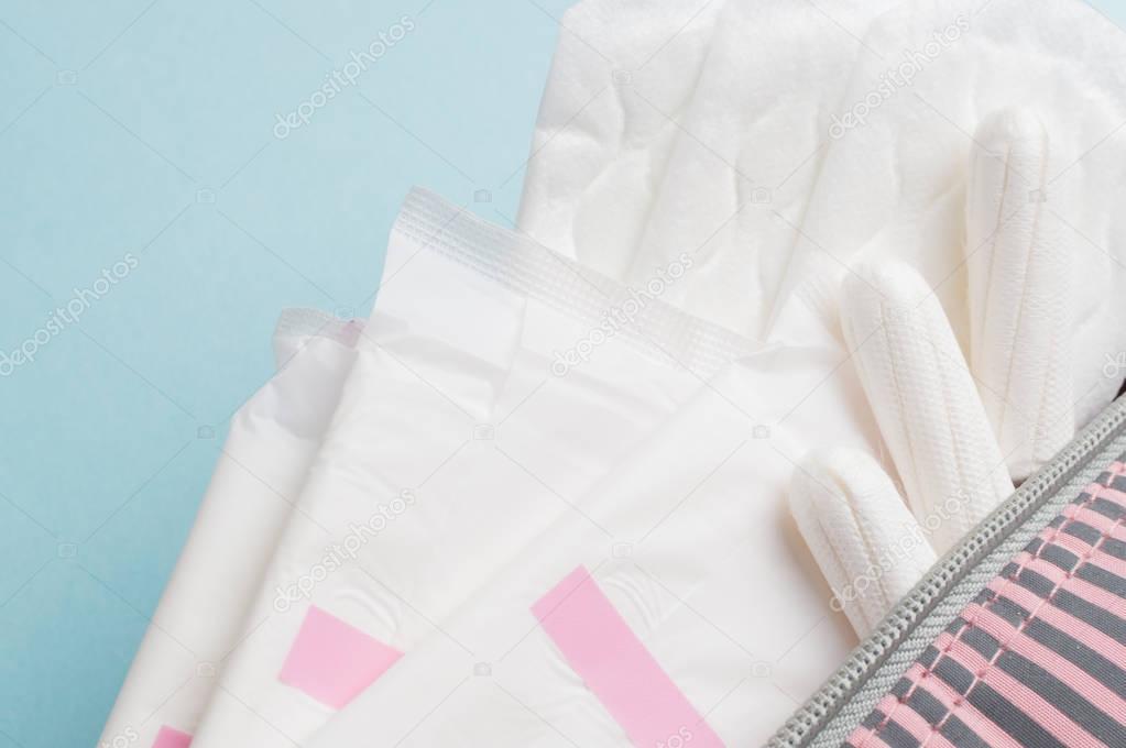 Menstrual tampons and pads in cosmetic bag. Menstruation cycle. Hygiene and protection