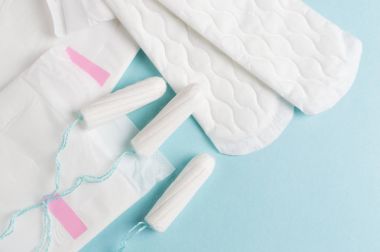 Adet tampon ve yastıkları mavi bir arka plan üzerinde. Adet zamanı. Hijyen ve koruma