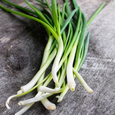 Ahşap masa üzerinde yeşil genç soğan. Rustik tarzı. kare