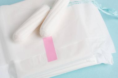 Adet tampon ve yastıkları mavi bir arka plan üzerinde. Adet zamanı. Hijyen ve koruma