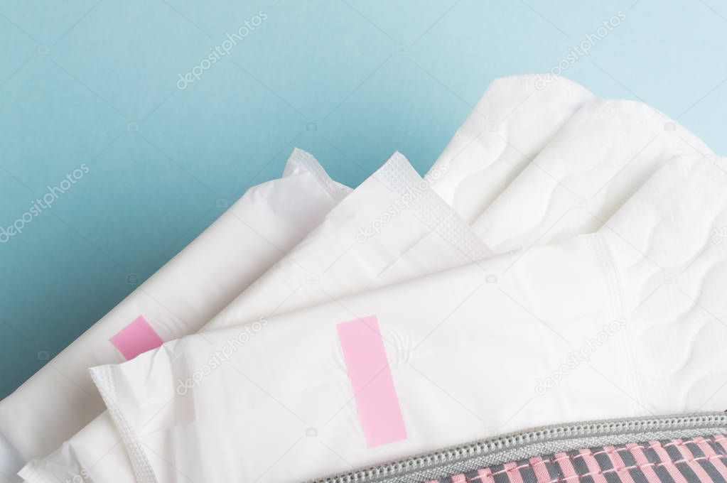 Menstrual tampons and pads in cosmetic bag. Menstruation time. Hygiene and protection