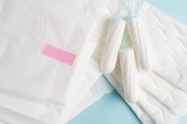 Adet tampon ve yastıkları mavi bir arka plan üzerinde. Adet zamanı. Hijyen ve koruma