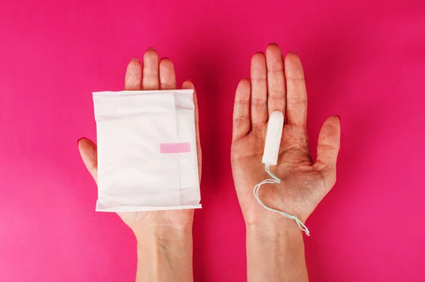 Mulher segurando tampão menstrual em um fundo rosa. Hora da menstruação. Higiene e protecção — Fotografia de Stock