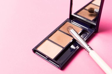 Pembe bir arka plan üzerinde gölgeler ile fırça. Makyaj aksesuarları.