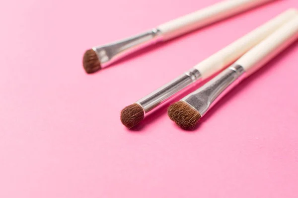 Makeup accessories. Set of brushes for makeup on the pink background. Womens cosmetic bag