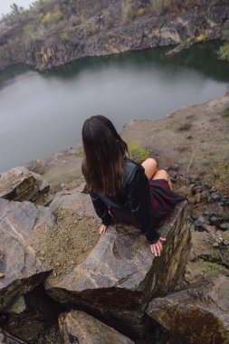 Göl, bir melanc yakınındaki bir kayada bir İskoç eteği bir kız oturuyor