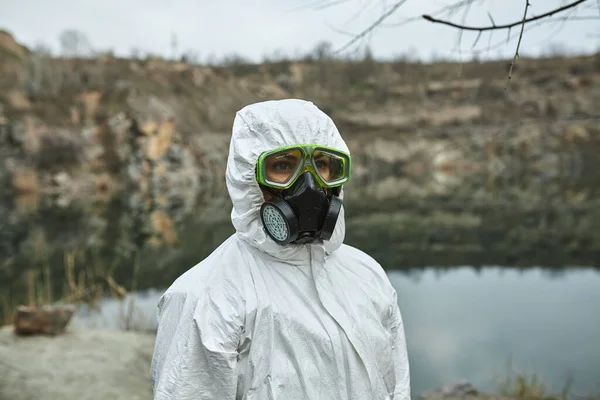 Koruyucu tulumlu bir kız. Biyolojik koruma giysisi, yüzünde maske ve gözlük. Virüsün bulaşmasını önlemek için kişisel koruyucu ekipman. Koronavirüs, salgın, grip ve karantina kavramı.