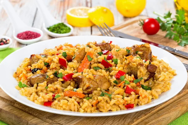 Paella com carne, pimentão, verduras e temperos em prato — Fotografia de Stock