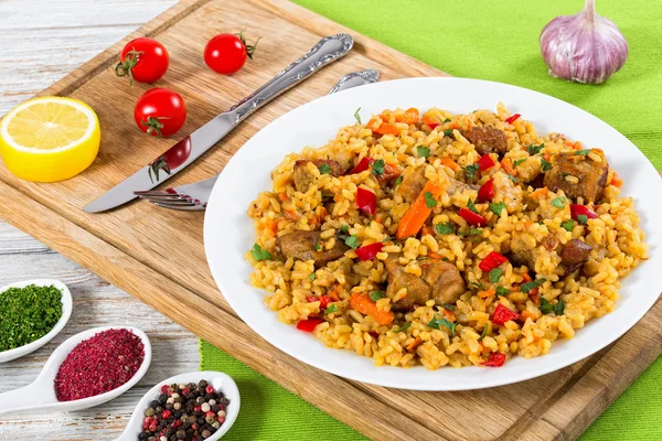Paella with meat, pepper, vegetables and spices on platter — Stock Photo, Image