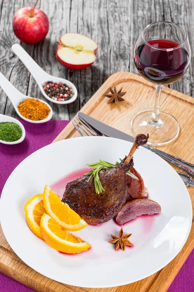 Kaki bebek panggang di piring dengan segelas anggur merah — Stok Foto