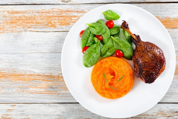 Roasted duck leg on platter with spinach and pumpkin porridge — Stock Image Roasted duck leg on platter with spinach and pumpkin porridge Royalty Free Stock Images