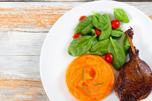 Roasted duck leg on platter with spinach and pumpkin porridge — Stock Image Roasted duck leg on platter with spinach and pumpkin porridge Stock Photo