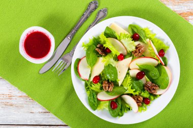 salad of apple, spinach, cheese, lettuce leaves, caramelized wal clipart