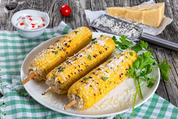 Grilled corn with cheese and parsley on white dish — Stock Photo, Image
