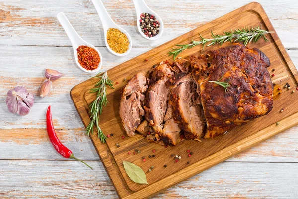 Oven-Barbecued Pork shoulder cut on slices on chopping board