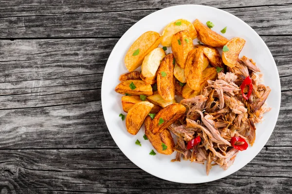 Gedeelte van getrokken langzaam gekookt vlees met gebakken aardappel partjes — Stockfoto