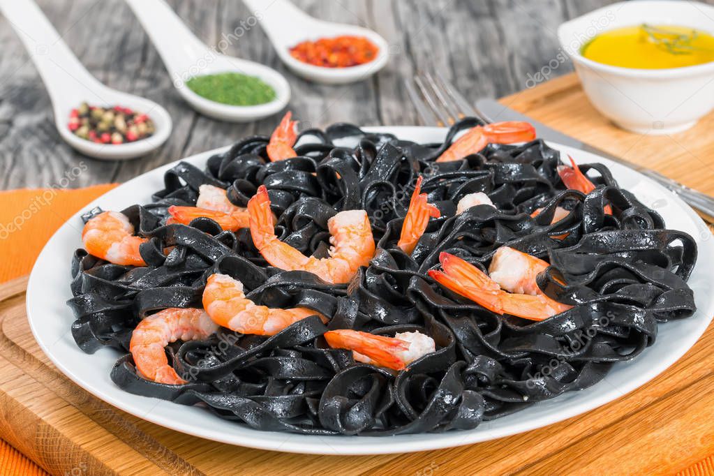 Squid ink black noodles with king prawns on white dish — Stock Photo