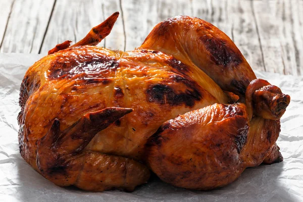 Delicioso frango inteiro assado no forno em pape pergaminho — Fotografia de Stock