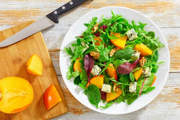 Salada com fatias de cáqui, mistura de folhas de alface, queijo azul — Fotografia de Stock