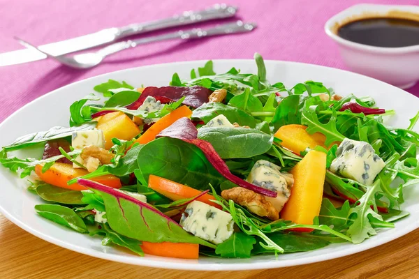 Salad with persimmon slices, mix of lettuce leaves, blue cheese — Stock Photo, Image