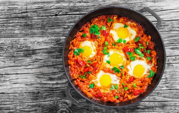 Delicioso shakshuka - huevos fritos, cebolla, pimientos, tomates y — Foto de Stock