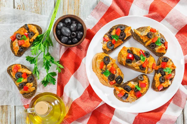 Bruschetta avec des morceaux de poisson sur plaque blanche — Photo