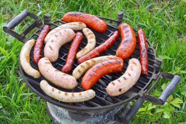 Grilled sausages on barbecue grill outdoor clipart
