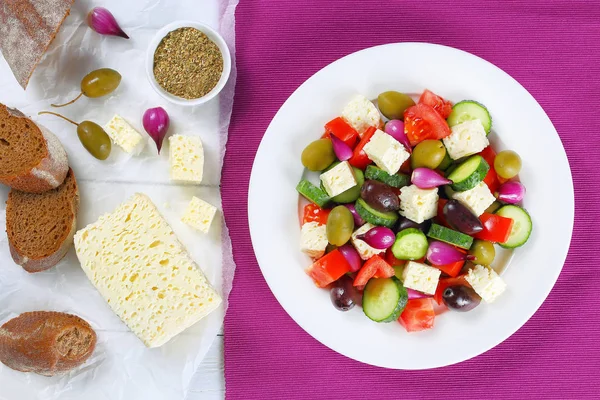 Ελληνική σαλάτα στο πιάτο, υλικά σε χαρτί — Φωτογραφία Αρχείου