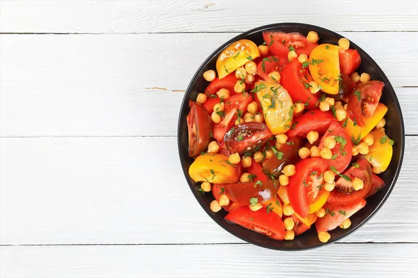 Веганський томатний салат з нуту в чорній мисці — стокове фото