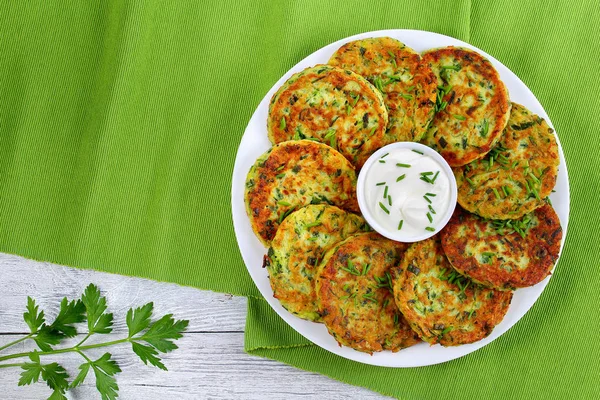 Delicious zucchini fritters on white plate — Stock Photo, Image