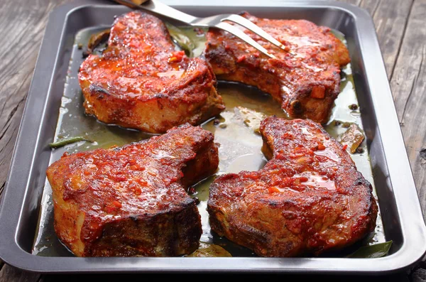 Sabrosos chuletas de cerdo en bandeja para hornear — Foto de Stock