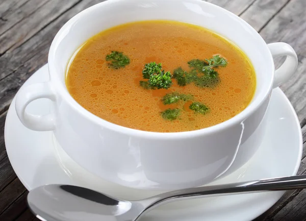 Chicken broth in a white soup cup