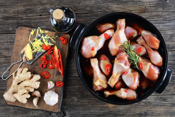 Raw chicken drumsticks in black pot — Stock Photo, Image