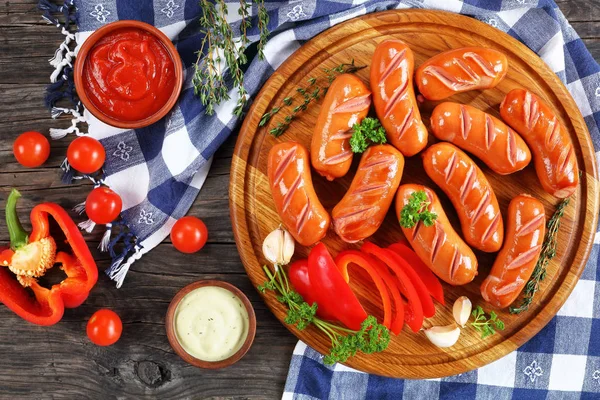 hot beef sausages on round cutting board