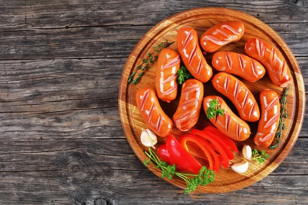 Beef sausages on round cutting board — Stock Photo, Image
