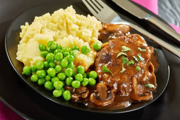 Close-up of salisbury steaks with green peas — Stock Photo, Image
