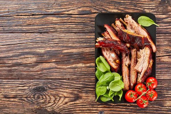 sliced BBQ ribs with fresh green spinach